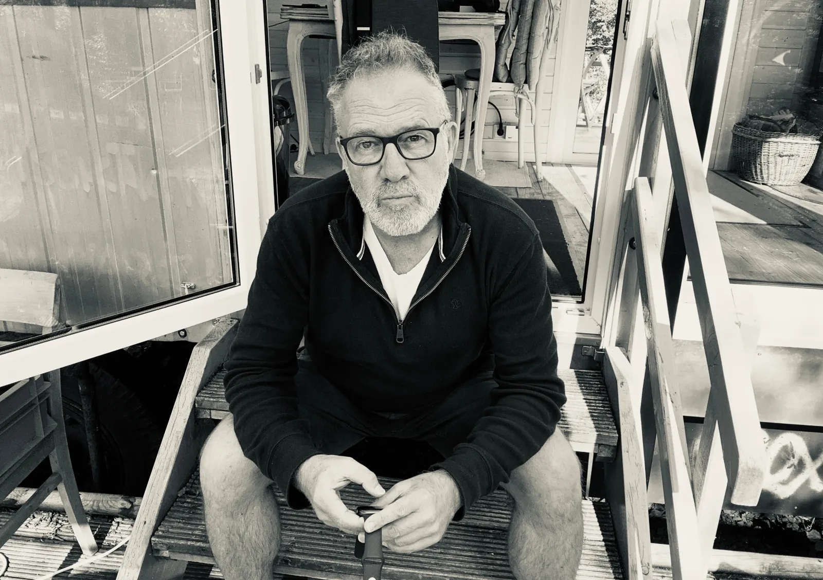 Daniel Wagner sitting on the wooden steps of his Bauwagen studio